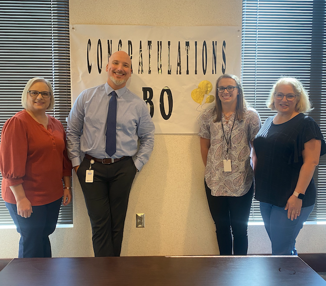 A group of people standing in front of a sign that says congratulations