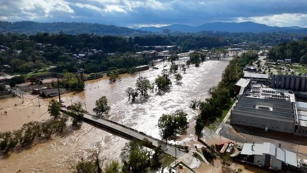 An aerial view of a flooded city with a bridge over a river.