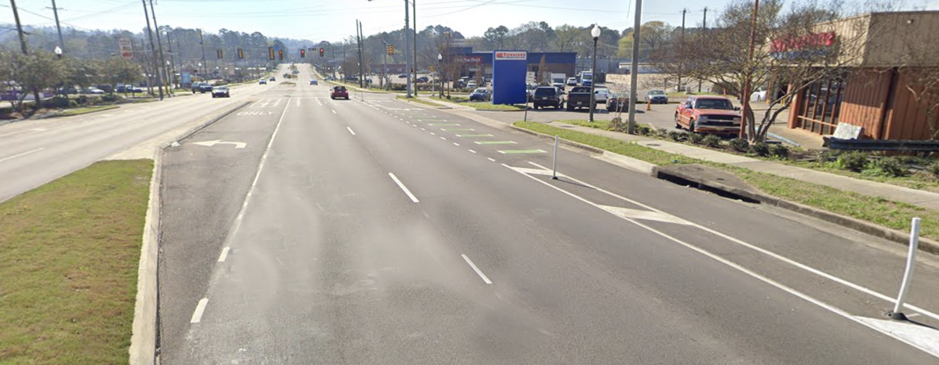 A street with a lot of cars driving down it