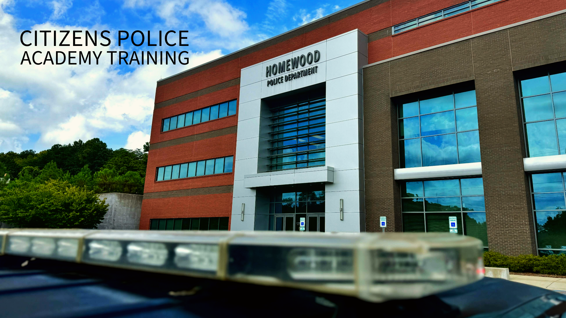 A police car is parked in front of the citizens police academy training building.