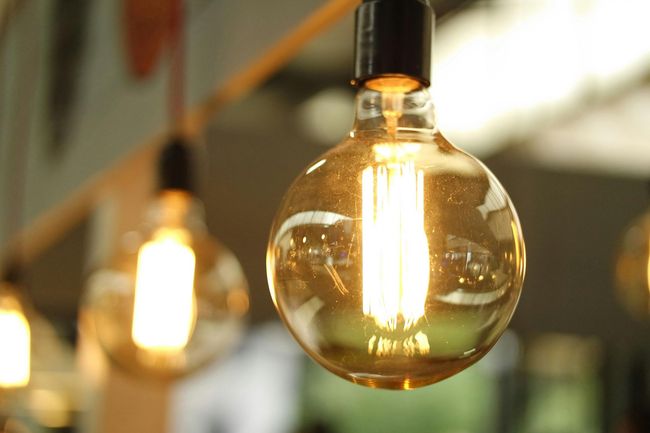 The Electric Pro - A close up of a light bulb hanging from a ceiling