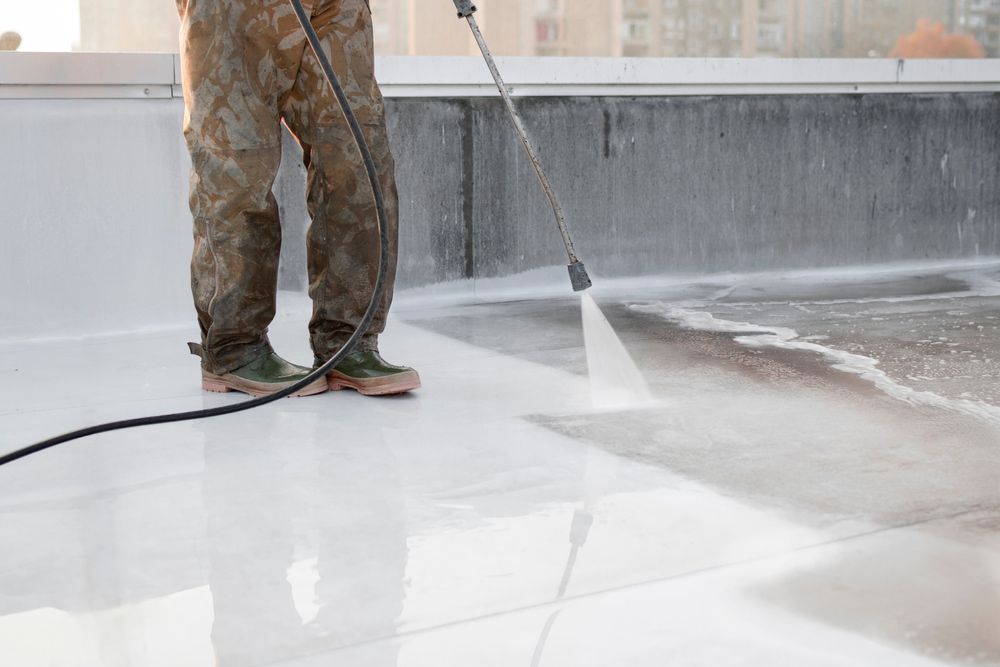 A man is using a high pressure washer to clean a roof — Roofworx Group In Lithgow, NSW.