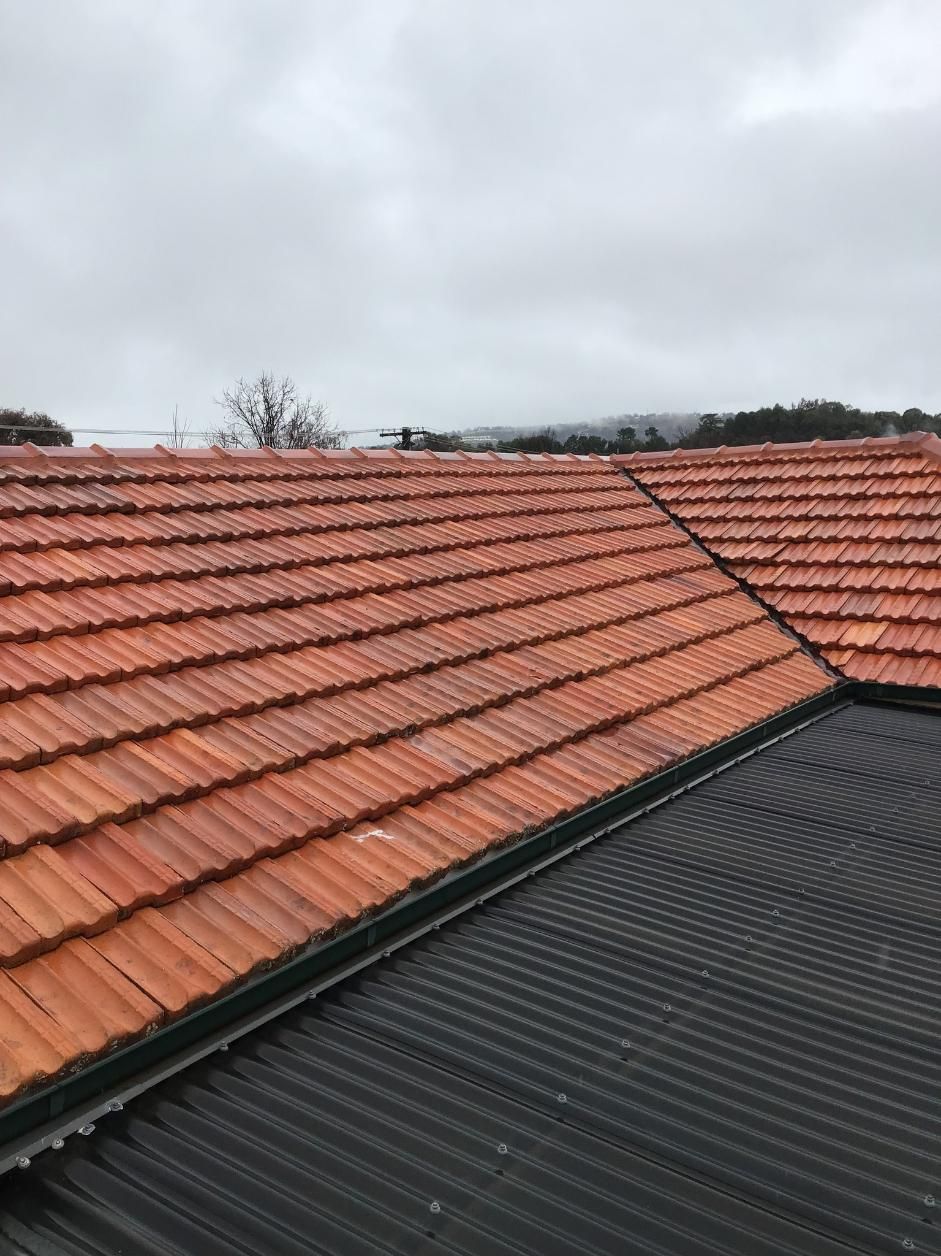 A close up of a tiled roof with a cloudy sky in the background — Roofworx Group In Bathurst, NSW