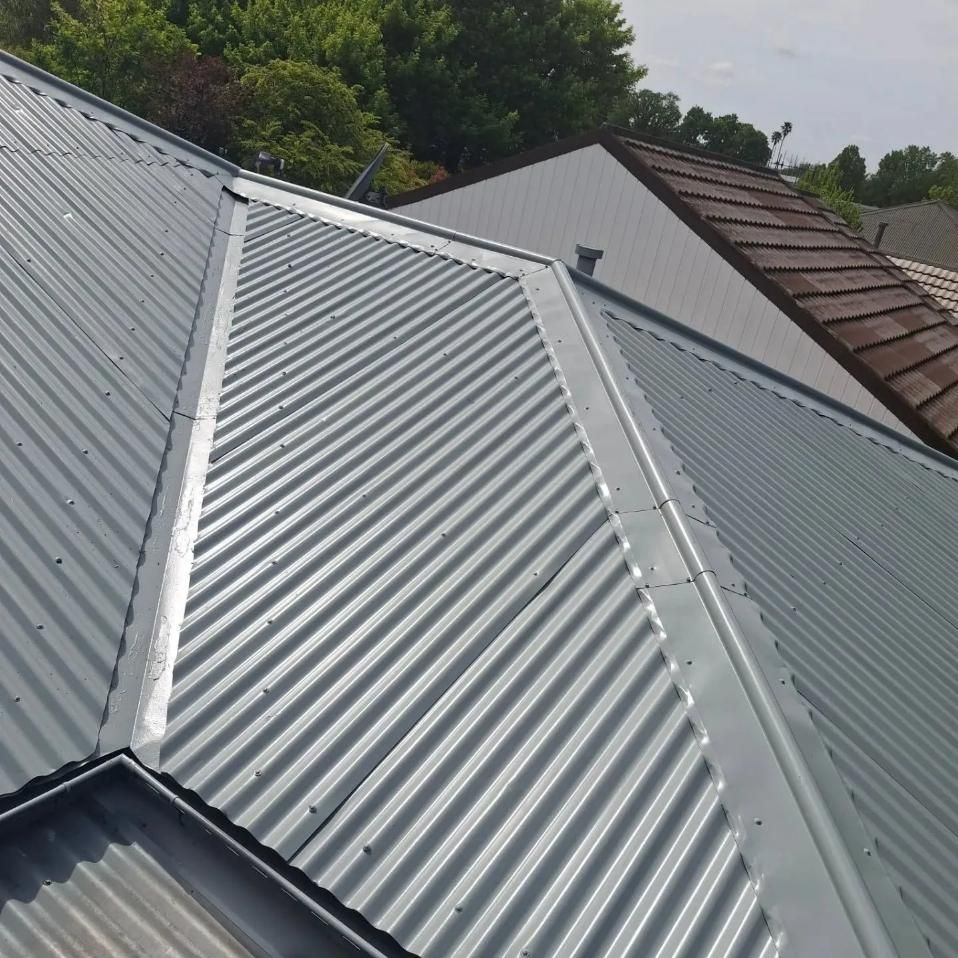 A close up of a metal roof with trees in the background — Roofworx Group In Lithgow, NSW