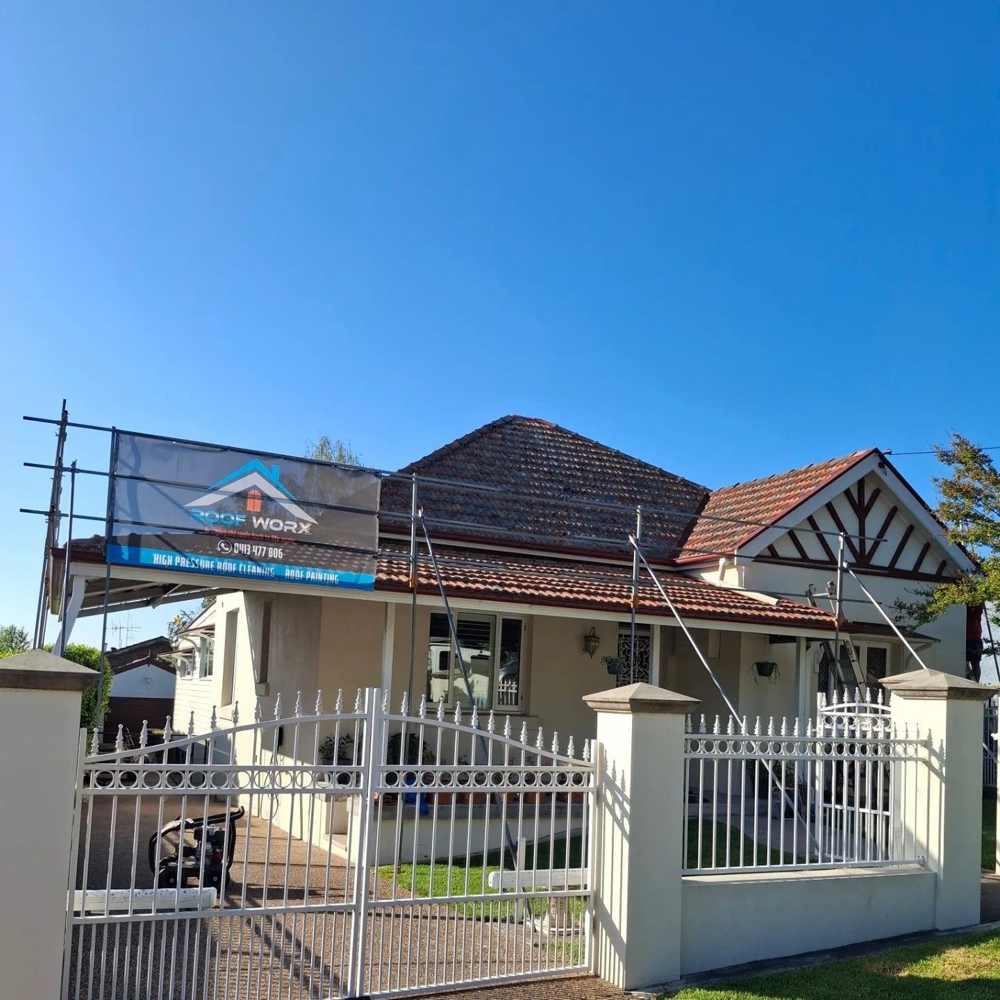 A house with a fence and scaffolding in front of it — Roofworx Group In Bathurst, NSW.