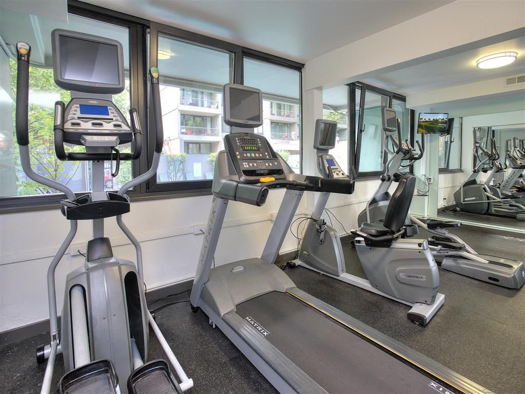 Cardio machines in a modern apartment community gym with treadmills and ellipticals at Harrison Tower