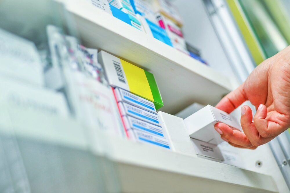 A Person is Taking a Box of Pills From a Shelf in a Pharmacy — Bluewater Pharmacy in Paluma, QLD