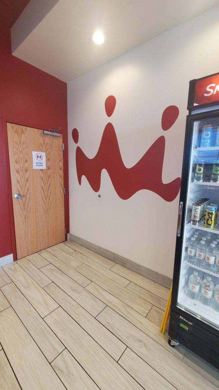 A red and white wall with the letter m painted on it