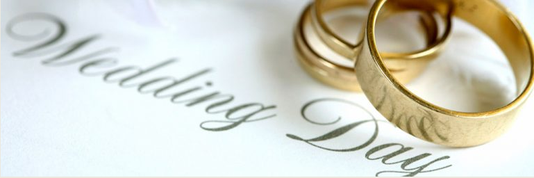 Gold wedding rings on a white surface beside the words “Wedding Day”