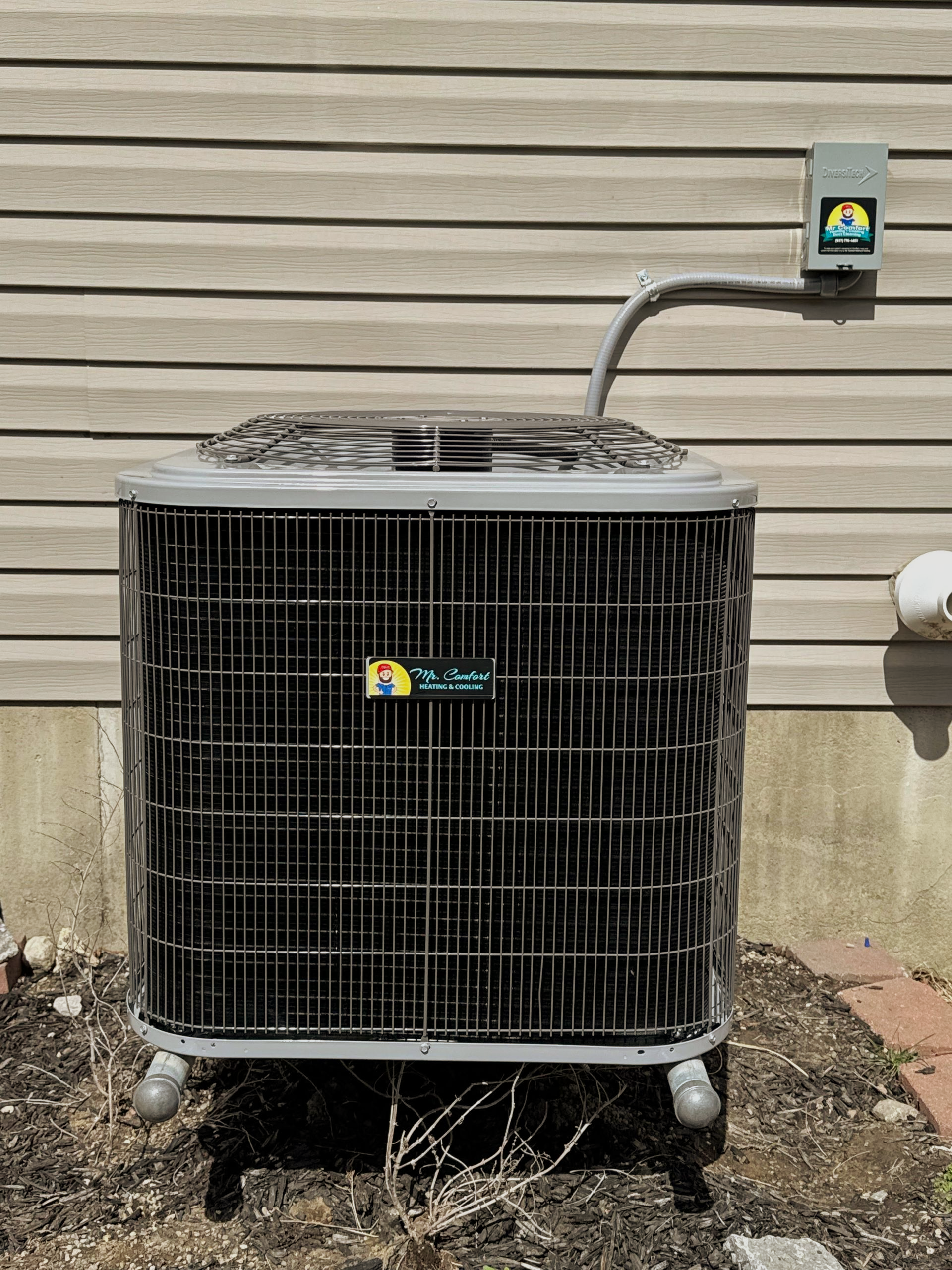 Man in white shirt and camo hat connecting tubing to a Carrier air conditioning unit on a rooftop.