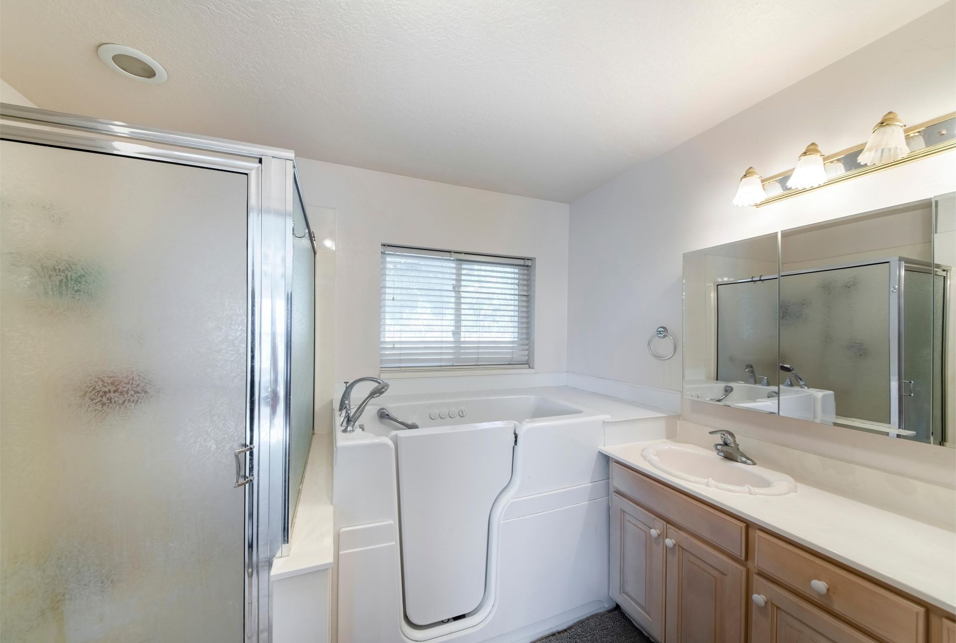 a bathroom with a walk in tub and a sink