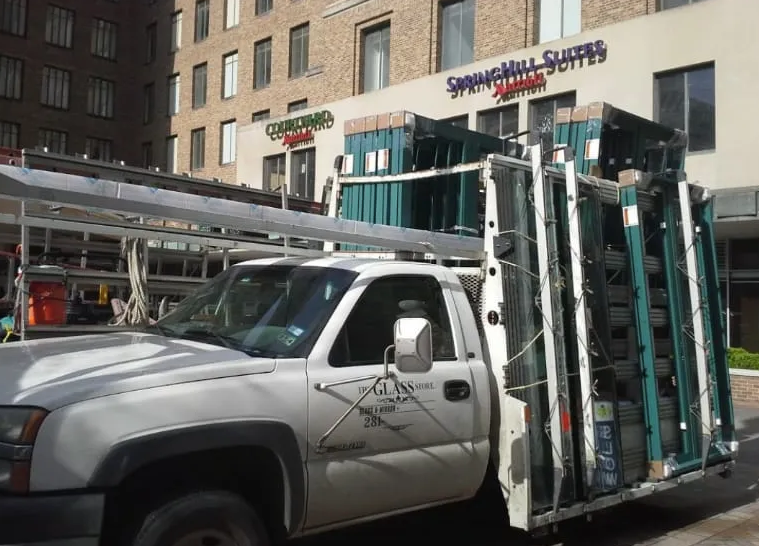 A white truck is parked in front of a building that says springhill suites