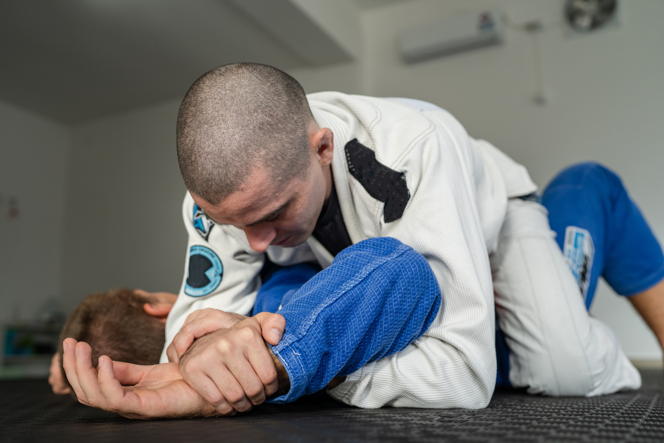 Adults drilling Jiu-Jitsu guard control at Almighty Jiu-Jitsu in Huntington Beach, CA.