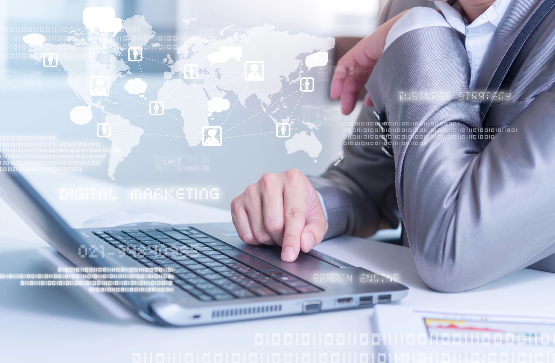 Uomo d'affari che utilizza un computer portatile alla scrivania, con grafici finanziari e icone digitali sullo sfondo.
