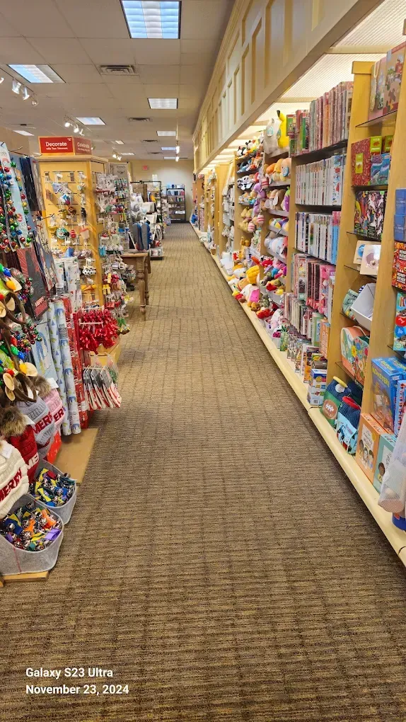 A store aisle lined with shelves of merchandise; toys and gifts on display.