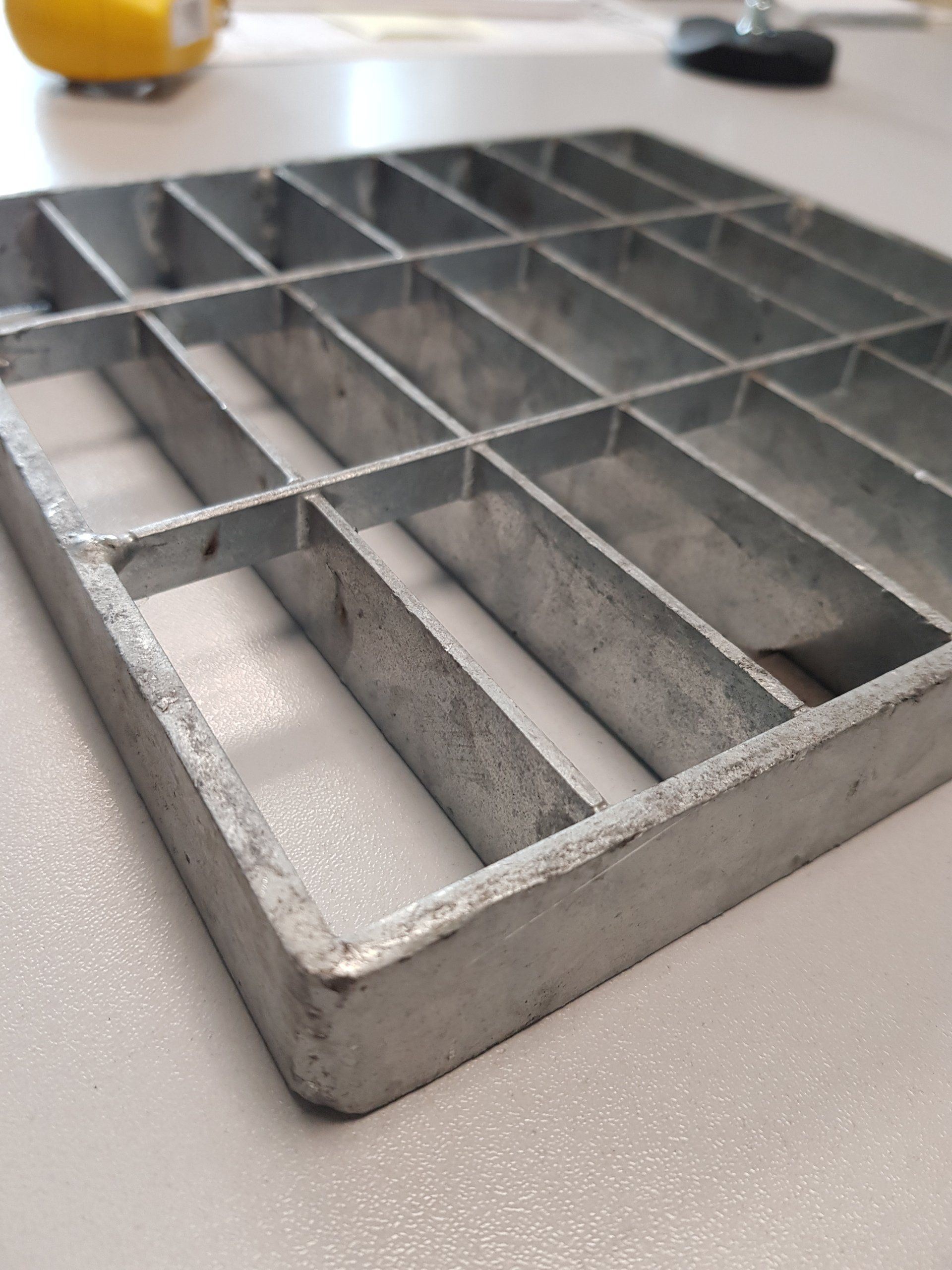 Vassoio organizer in metallo grigio con molteplici scomparti rettangolari da posizionare sul piano del tavolo.