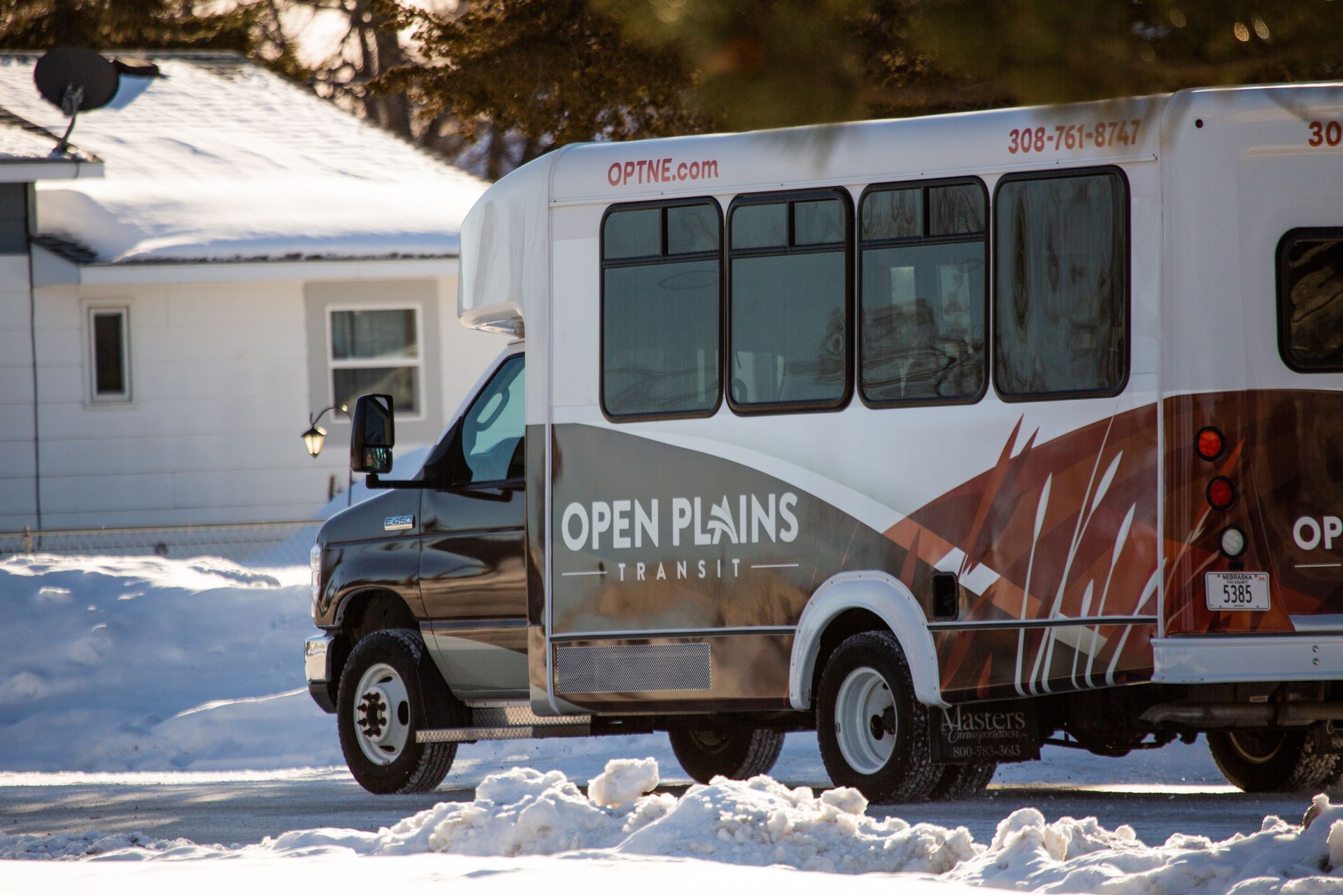 Photo of bus driving through residential neighborhood.