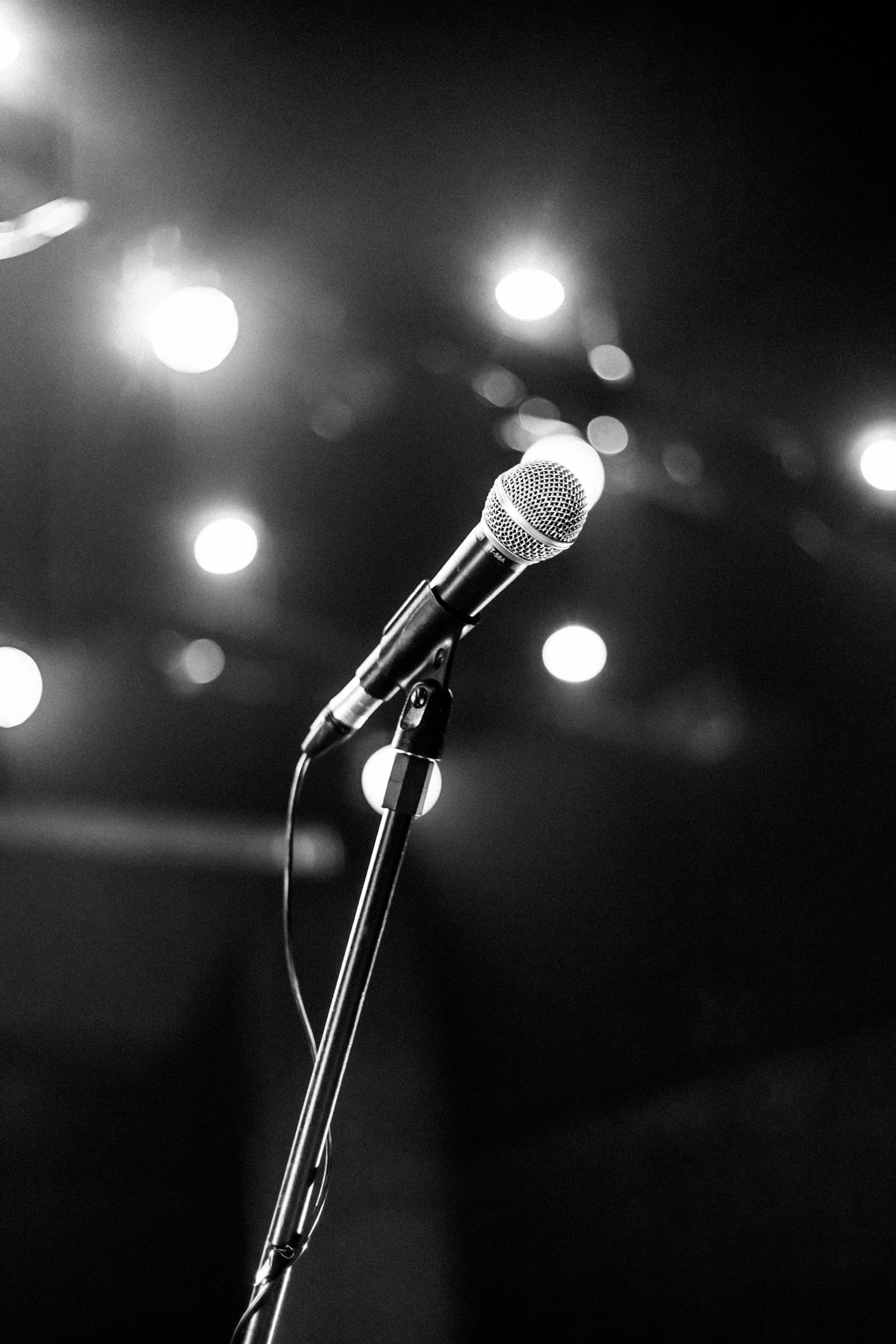 Microphone under stage lights representing speaking engagements, worship experiences, and live events by SoFree.