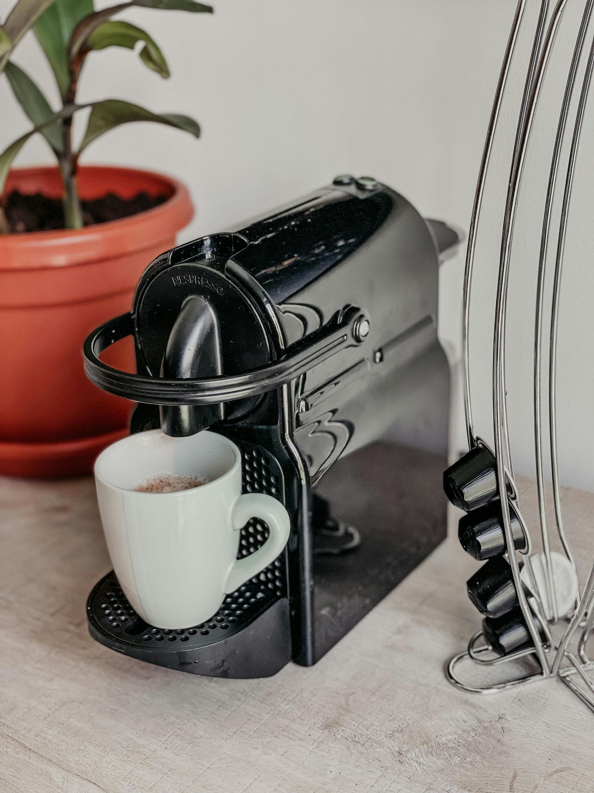 Kopje latte met latte art op een schoteltje en een lepel.