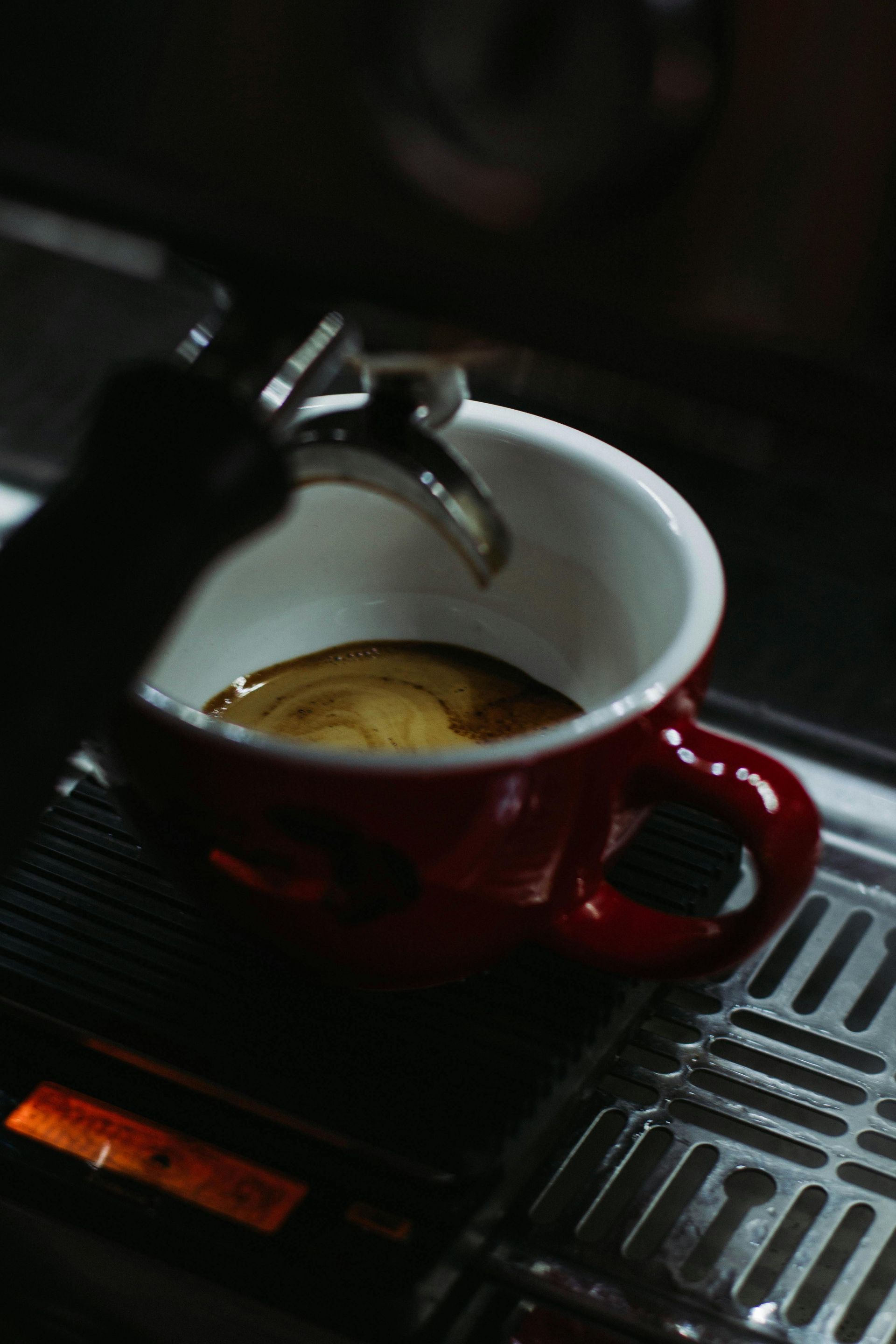 Kopje latte met latte art op een schoteltje en een lepel.