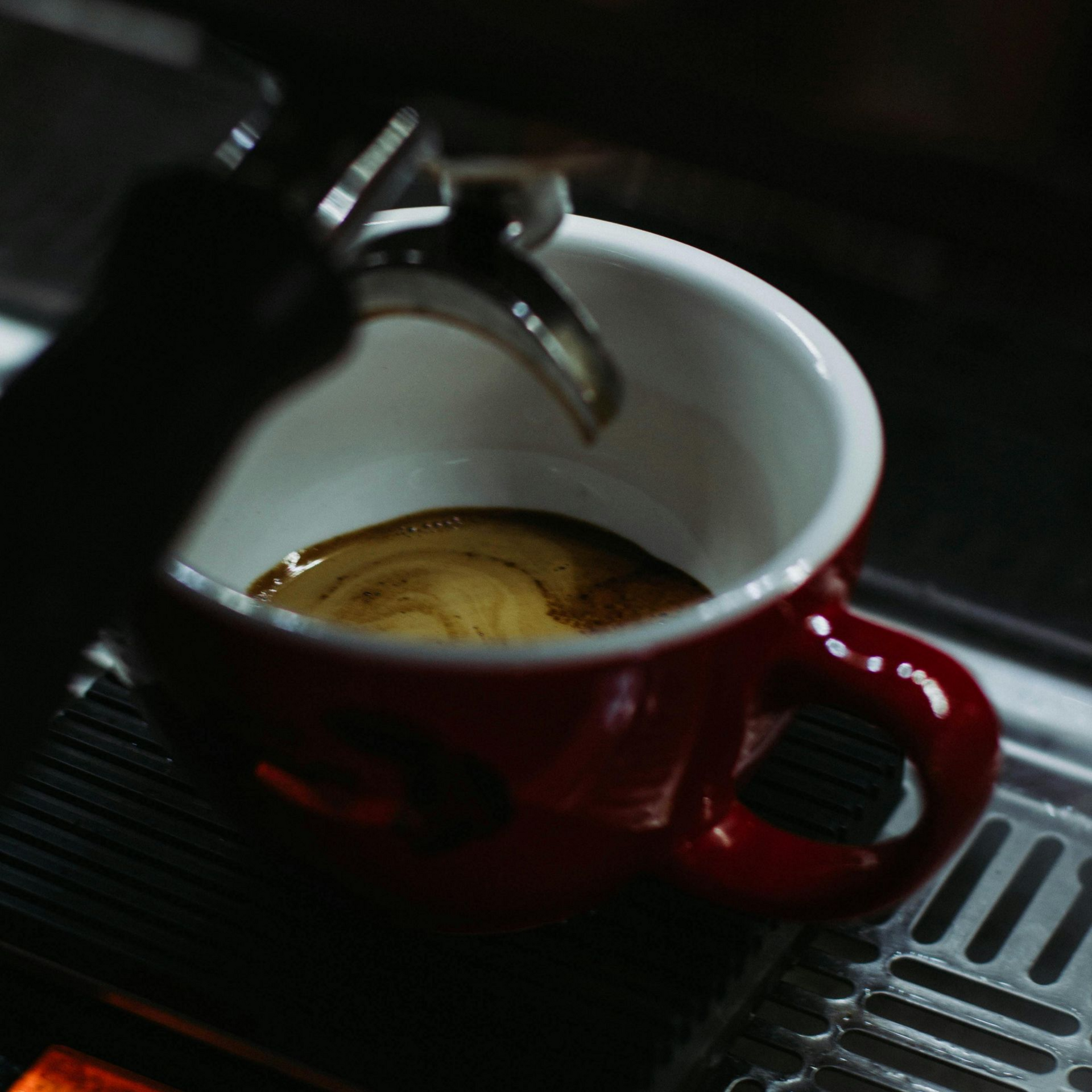 Kopje latte met latte art op een schoteltje en een lepel. 