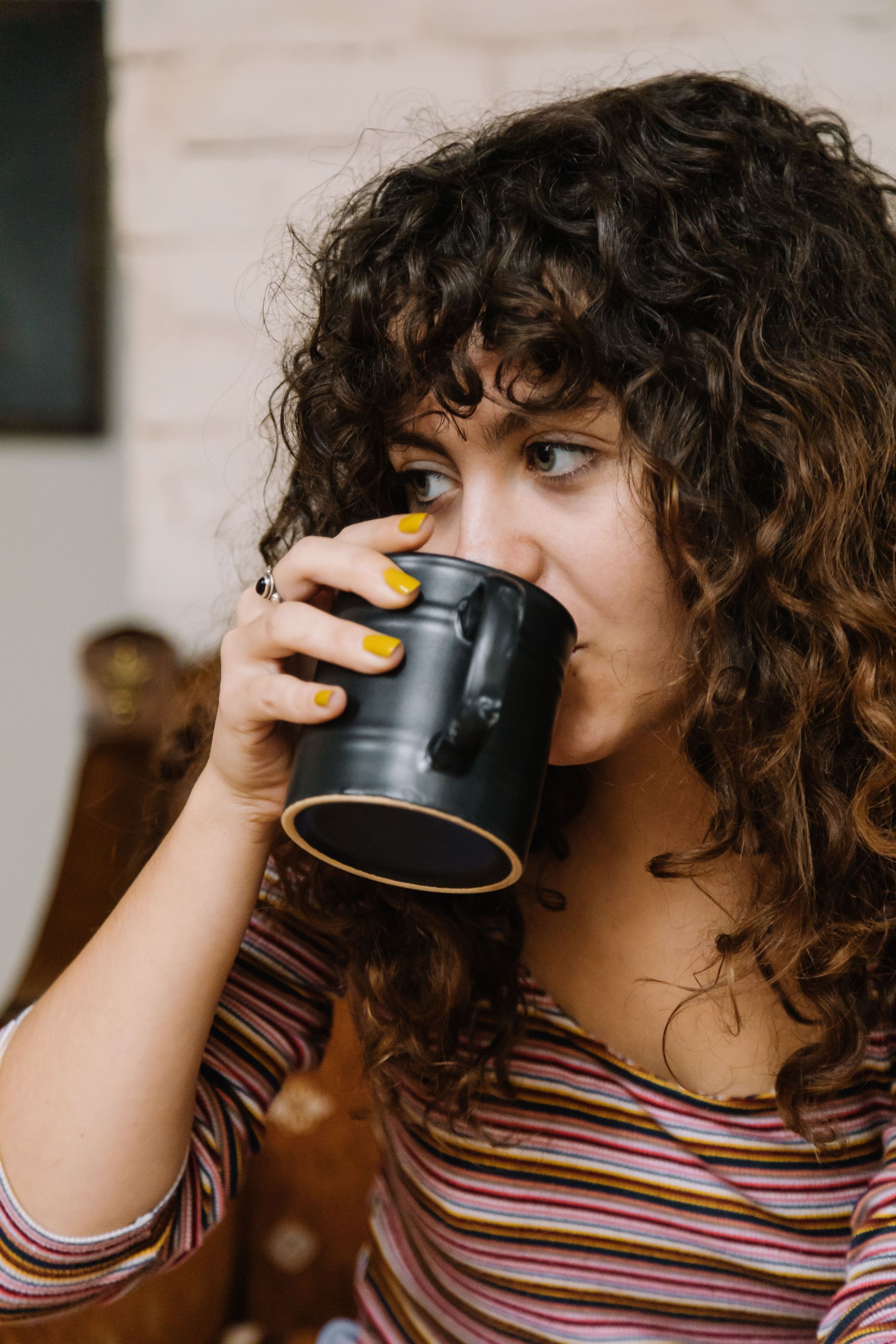 Kopje latte met latte art op een schoteltje en een lepel. 