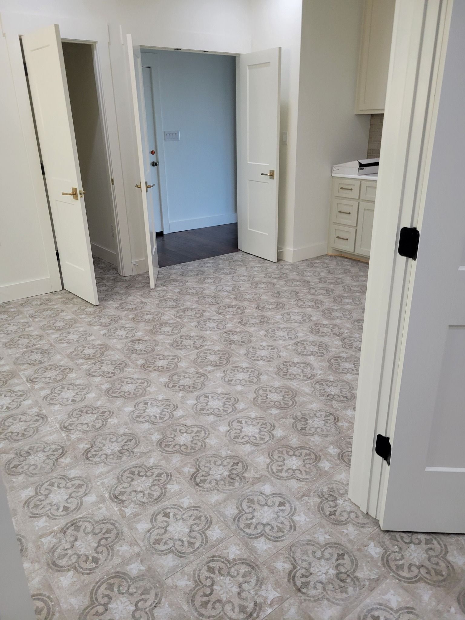 Empty room with beige patterned carpet and multiple open doors