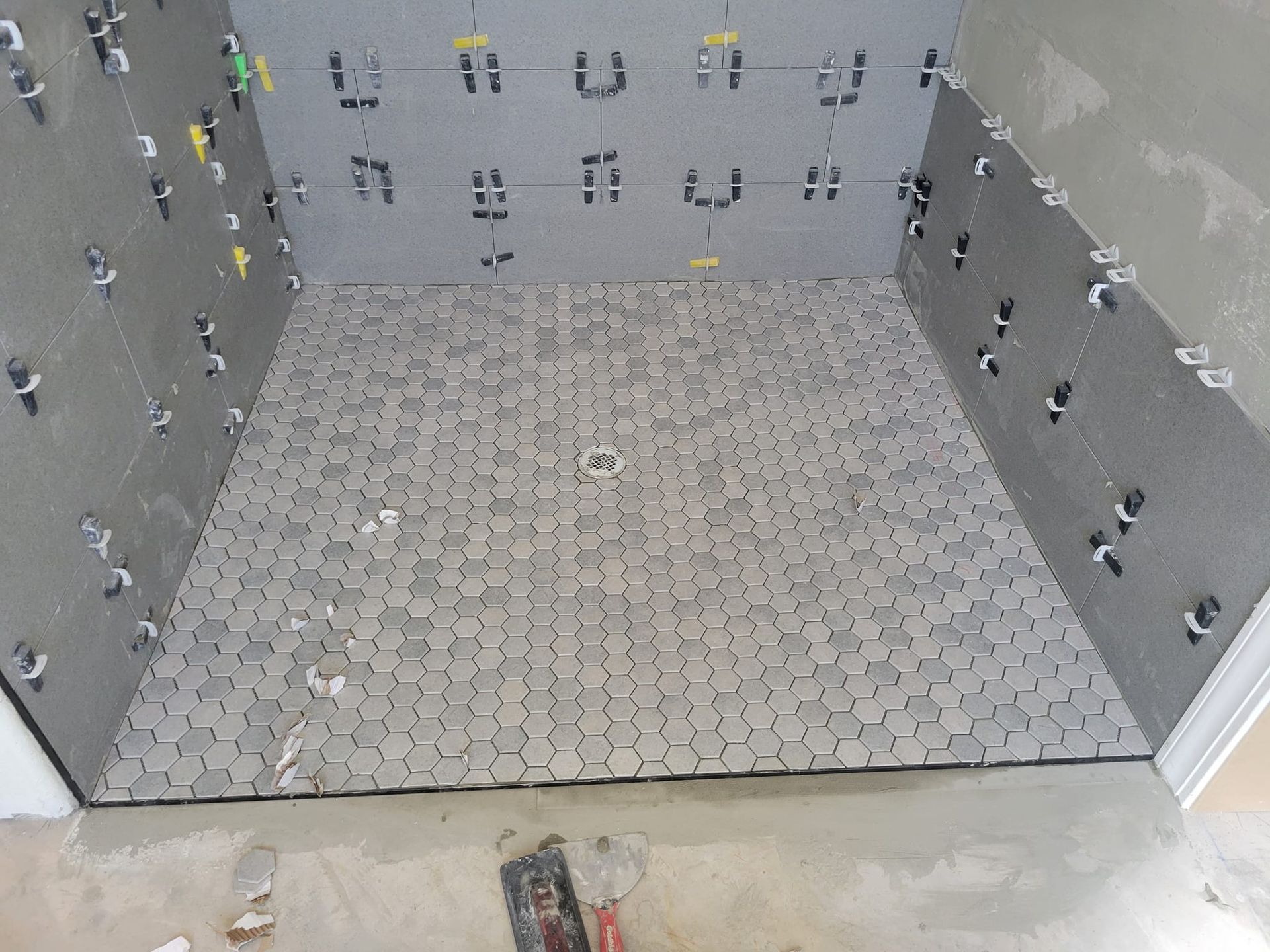 Empty gray tiled pit with patterned walls and floor drain