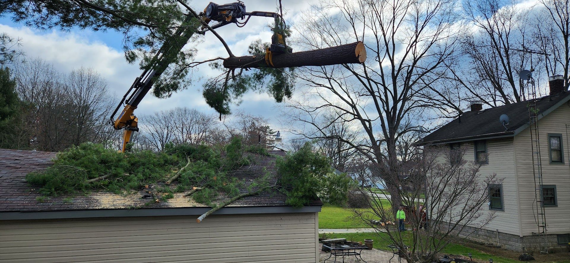 Tree is Being Cut Down by a Crane in Front of a House — Masury, OH — Hackett's Tree Service