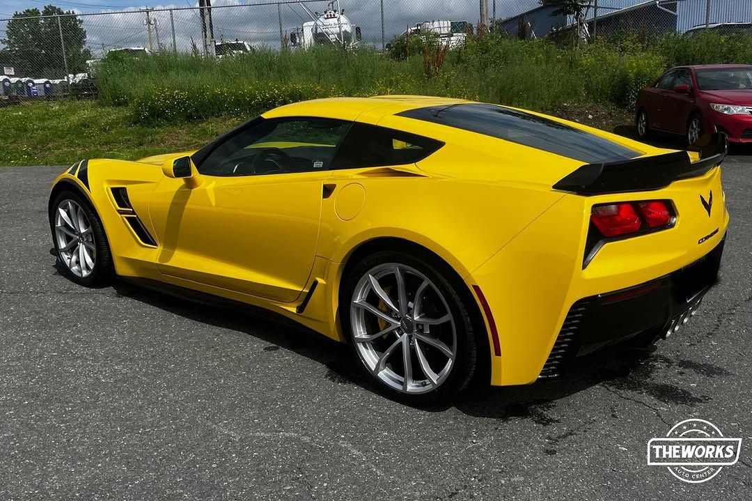 Yellow Chevrolet Corvette sports car parked on asphalt.