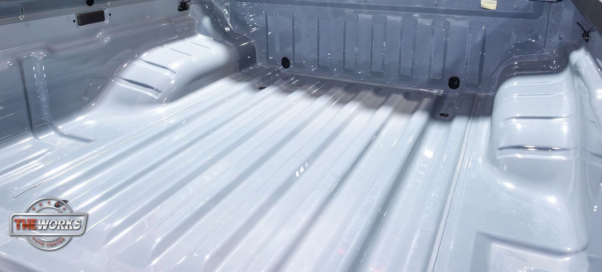 The inside of a truck bed is painted white.