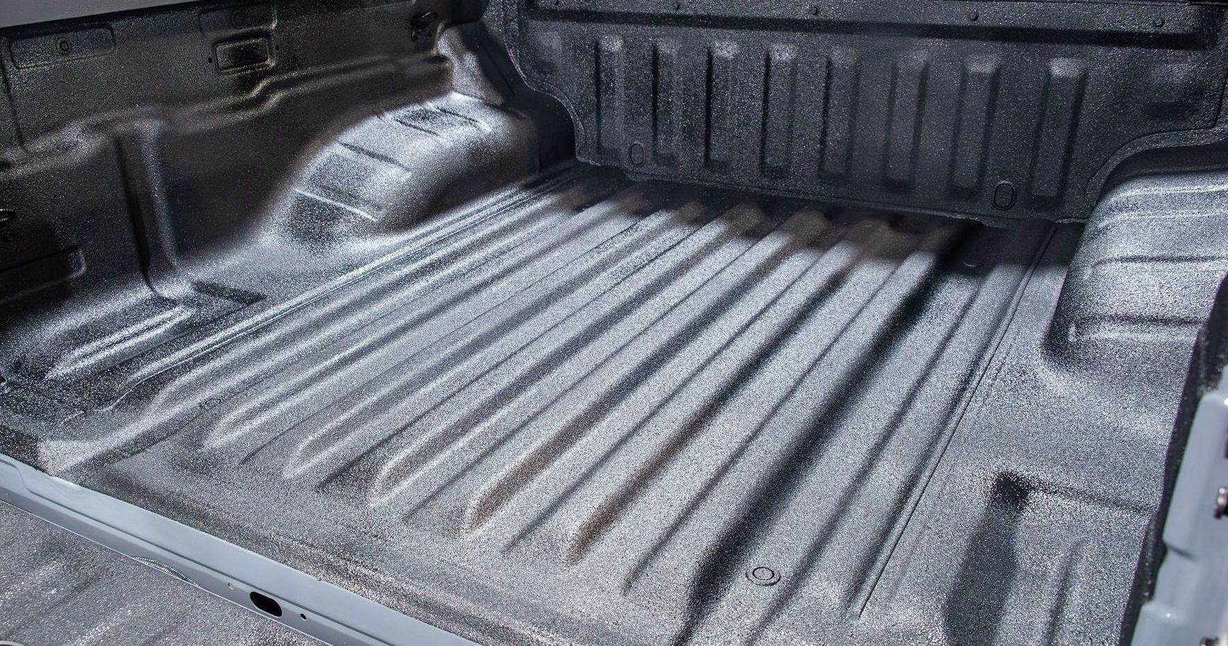 The bed of a truck is painted black and silver.
