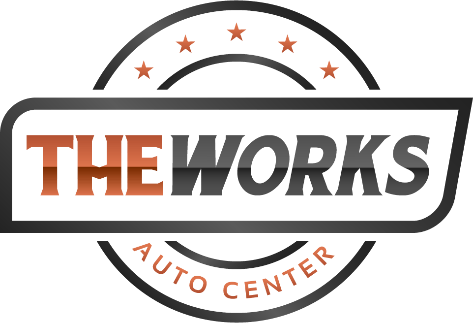 Logo for The Works Auto Center, with text on a rectangle framed by a circle and stars.