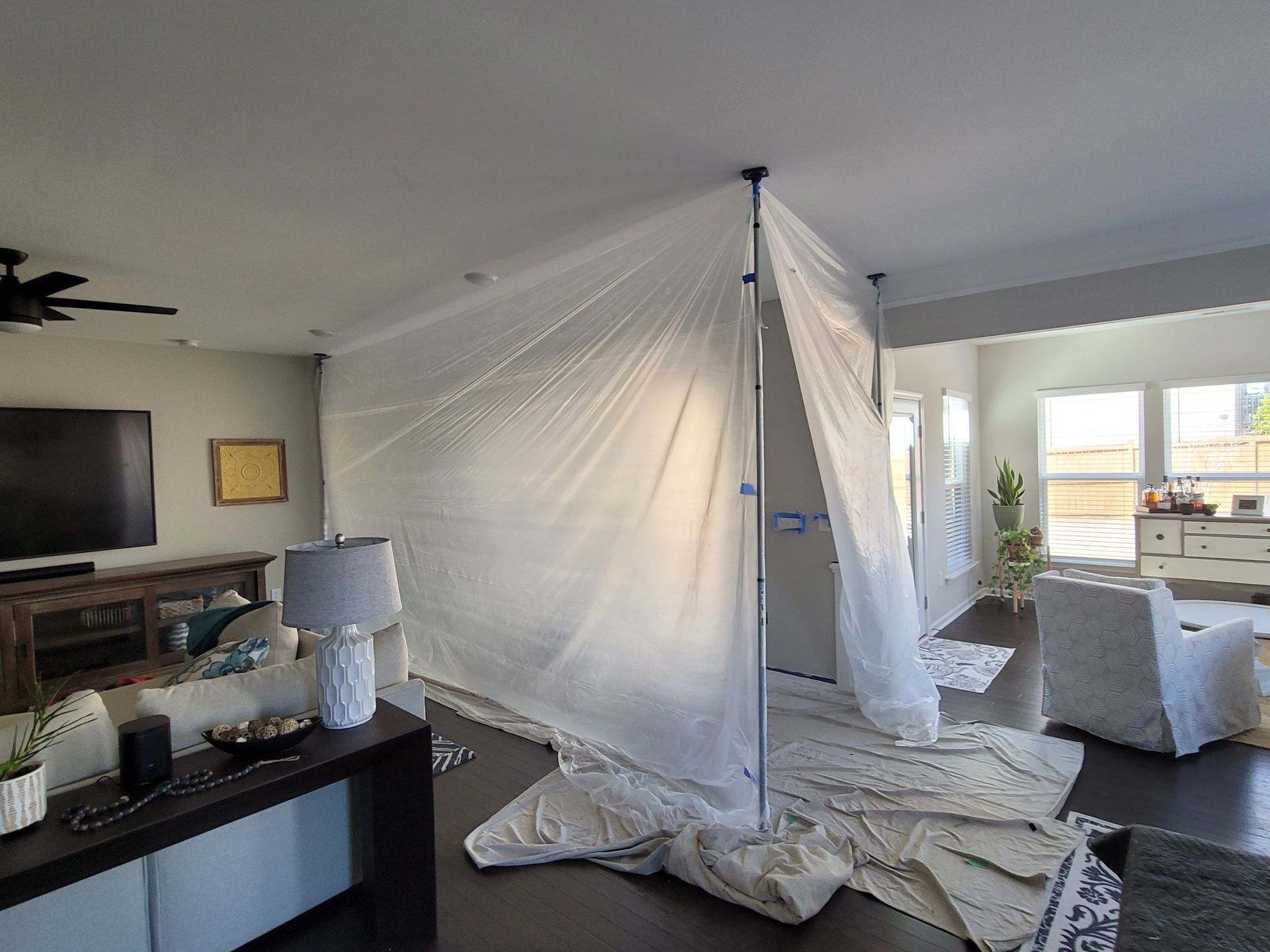 Living room with a large white mosquito net or tent draped from the ceiling over furniture