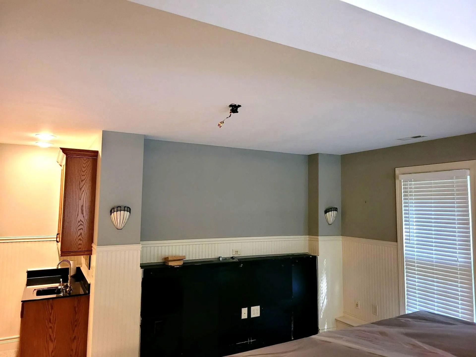 Empty living room with gray walls, fireplace, and sliding glass door with blinds