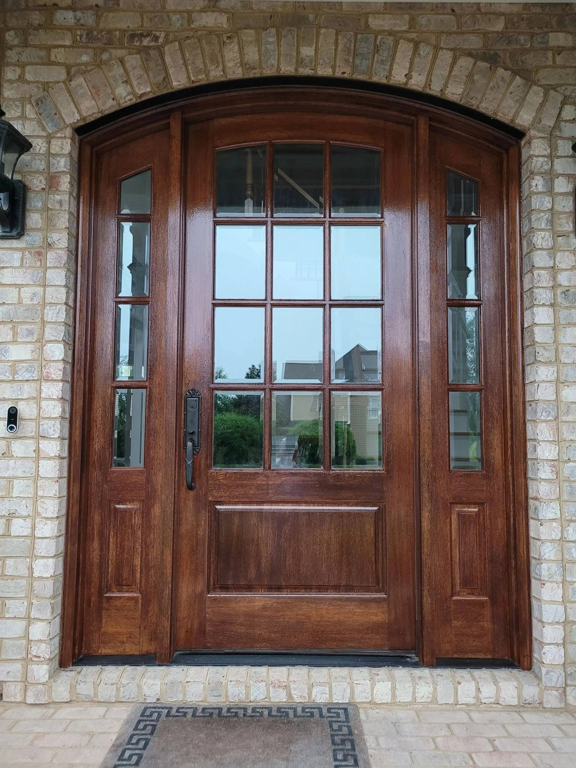 Wooden front door with glass panels set in a stone facade