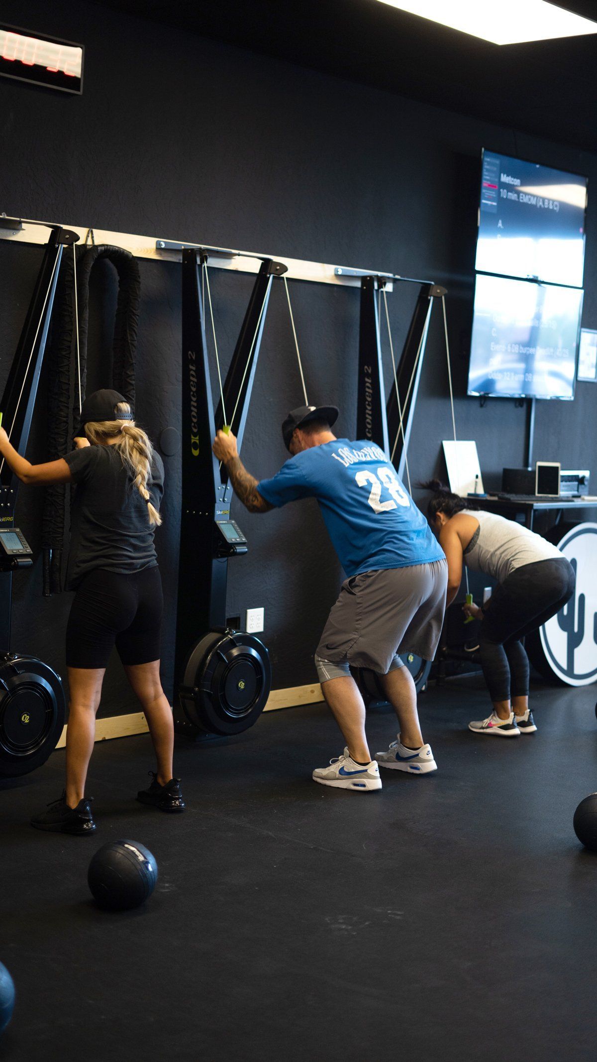 People exercising on curved treadmillsAZFITCO, a gym in Chandler, AZ,with a black medicine ball on the floor.