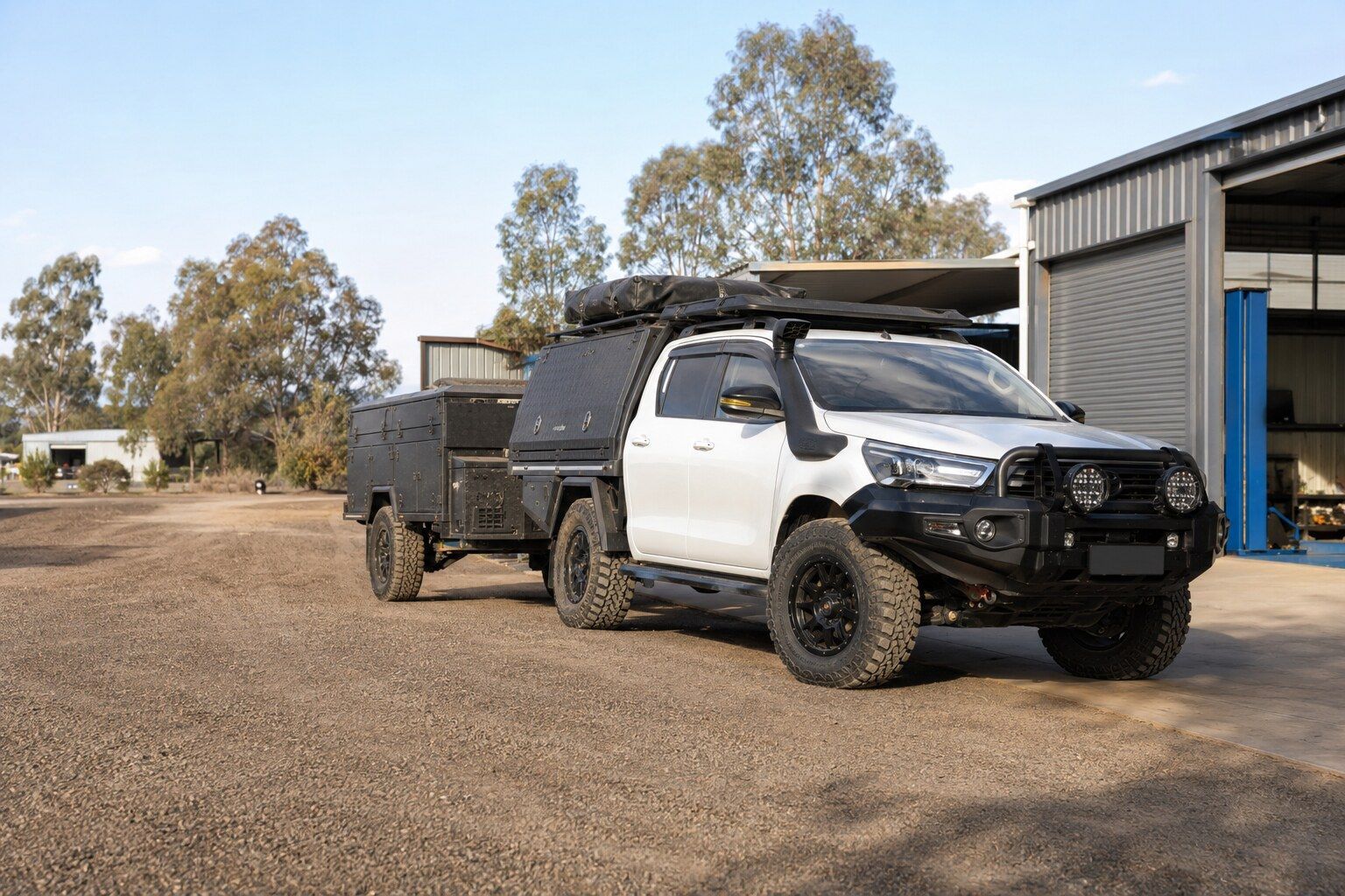 White off-road truck with canopy and trailer parked on a gravel driveway beside a metal shed — Mechanical World In Wagga Wagga, NSW