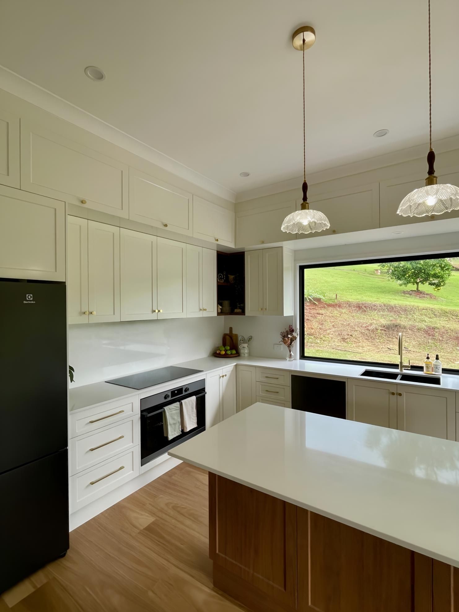 A Kitchen With White Cabinets, a Black Refrigerator and a Large Island— BM Cabinetry In Spring Grove, NSW