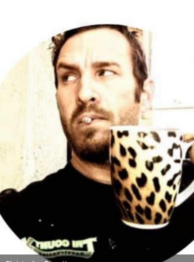 Man holding a leopard-print mug and looking sideways in a close-up shot