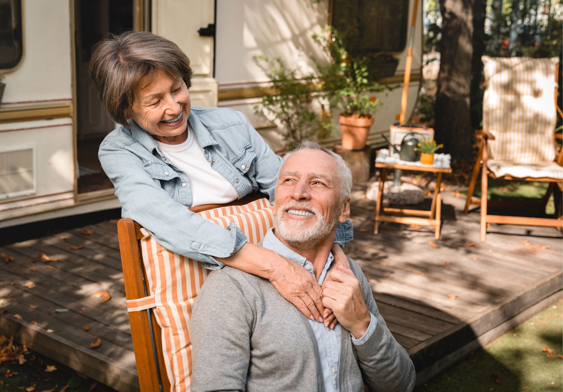 A woman is sitting on the back of a man in a chair.