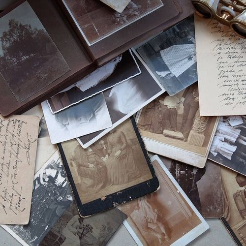A pile of old photographs and letters on a table