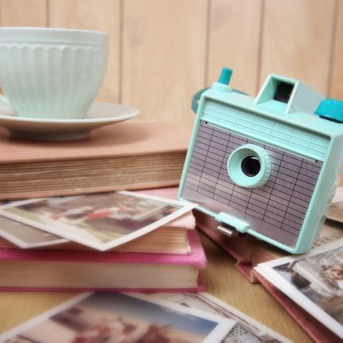 A small camera is sitting on top of a stack of books