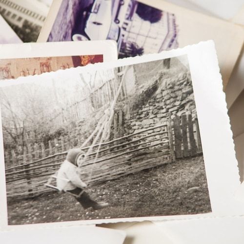 A black and white photo of a child on a swing