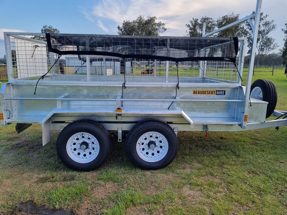 A trailer is sitting on top of a lush green field. — Beaudesert Equipment Hire Services in Beaudesert, QLD