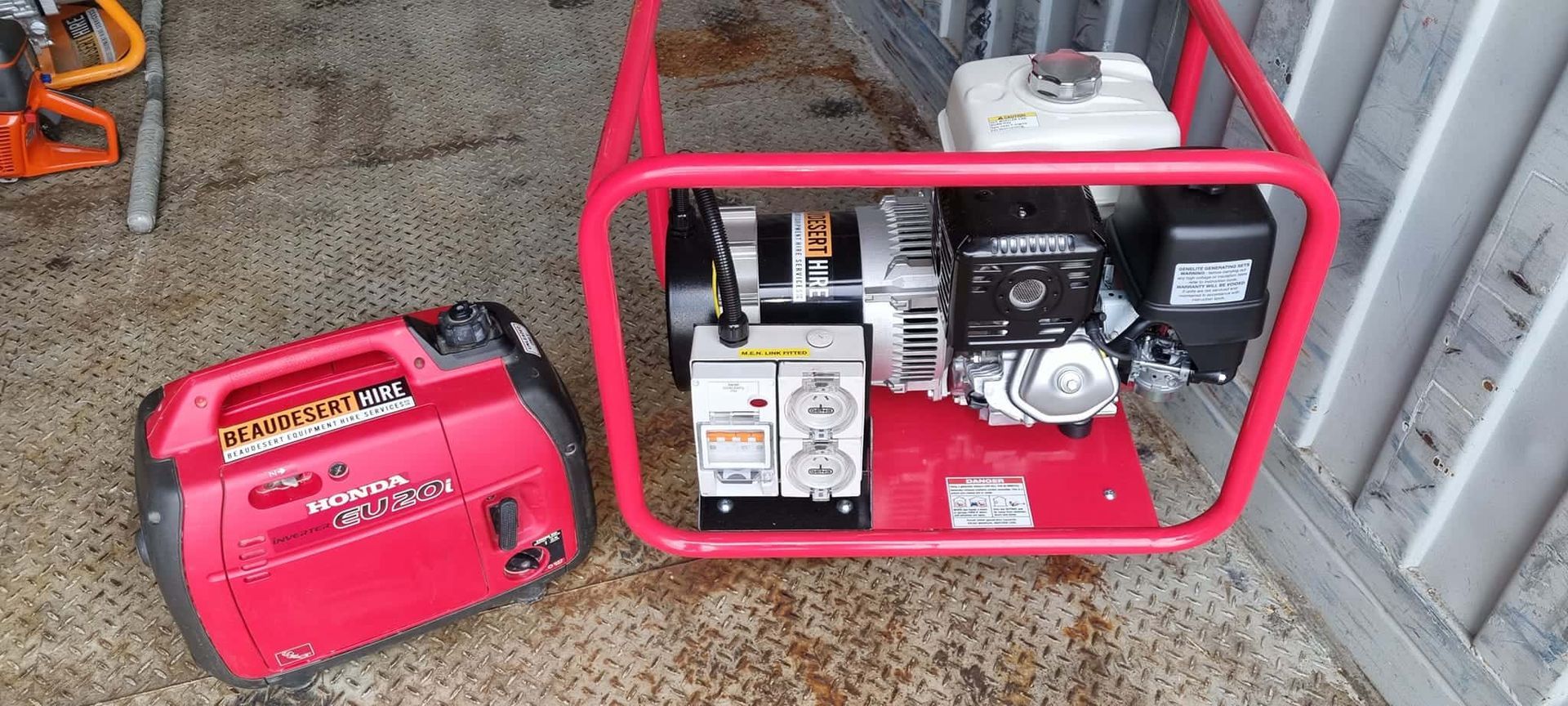 A red generator is sitting next to a smaller generator. — Beaudesert Equipment Hire Services in Beaudesert, QLD