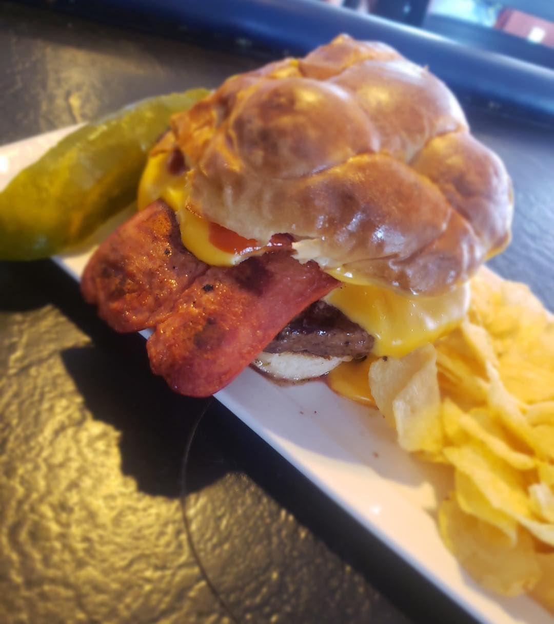 A sandwich with a pickle and chips on a plate