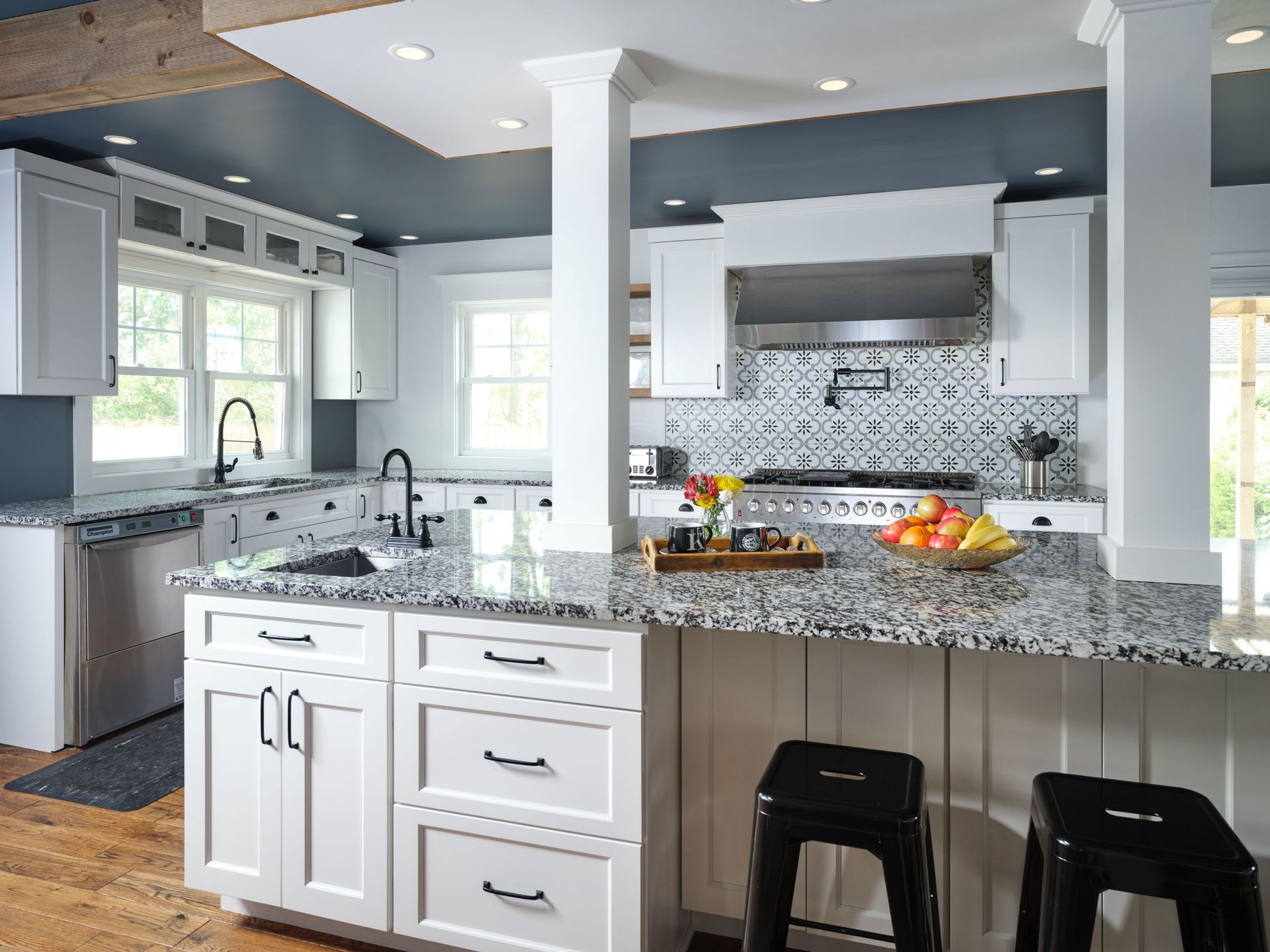 A kitchen with white cabinets and granite counter tops.