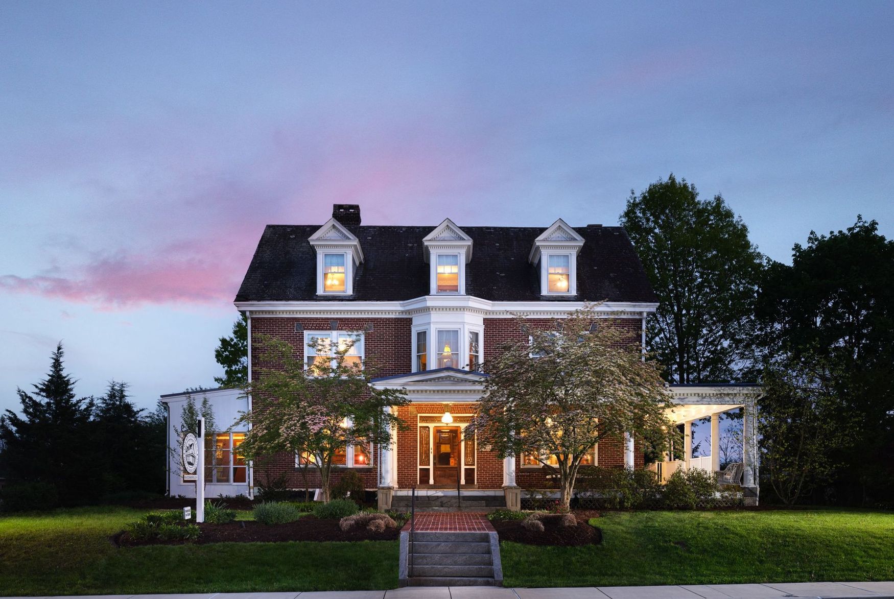 A large house with a lot of windows is lit up at night