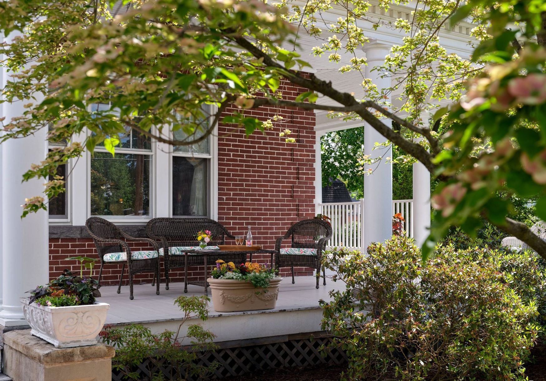 There is a porch with a couch and chairs on it.